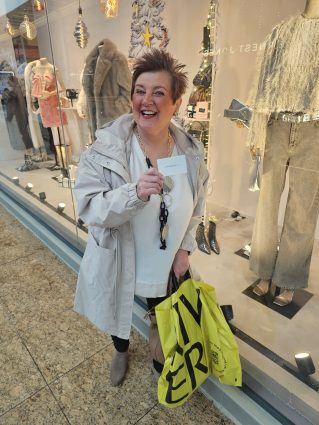 A person smiling holding shopping bags