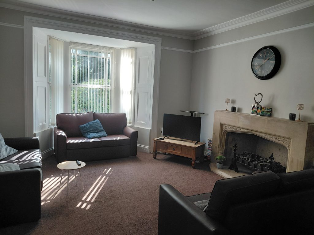 Living room with sofa, fireplace, and tv