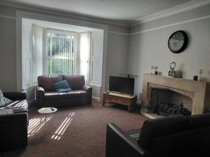 Living room with sofa, fireplace, and tv