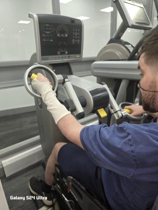 A man using an arm bike in a gym