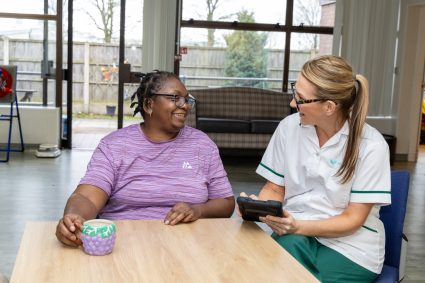 Two women sat at a table talking to each other
