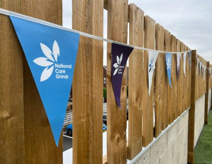 Bunting with National Care Group branding hung on a fence